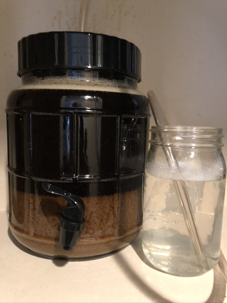 Fermenter in closet with blow-off tube fitted, hop matter settling out