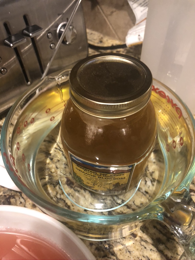 Letting jar of honey sit in warm water